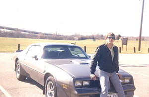 In 1986 as a high school senior with my first T/A, a 1977 W72 4-speed hood bird delete car.  Check out the cheezy moustache and the Member's Only jacket.